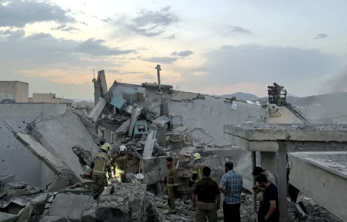 ISRAEL-IRAN Des civils et des secouristes rassemblés au sommet d’un bâtiment touché par une frappe israélienne à Téhéran, le 13 juin 2025